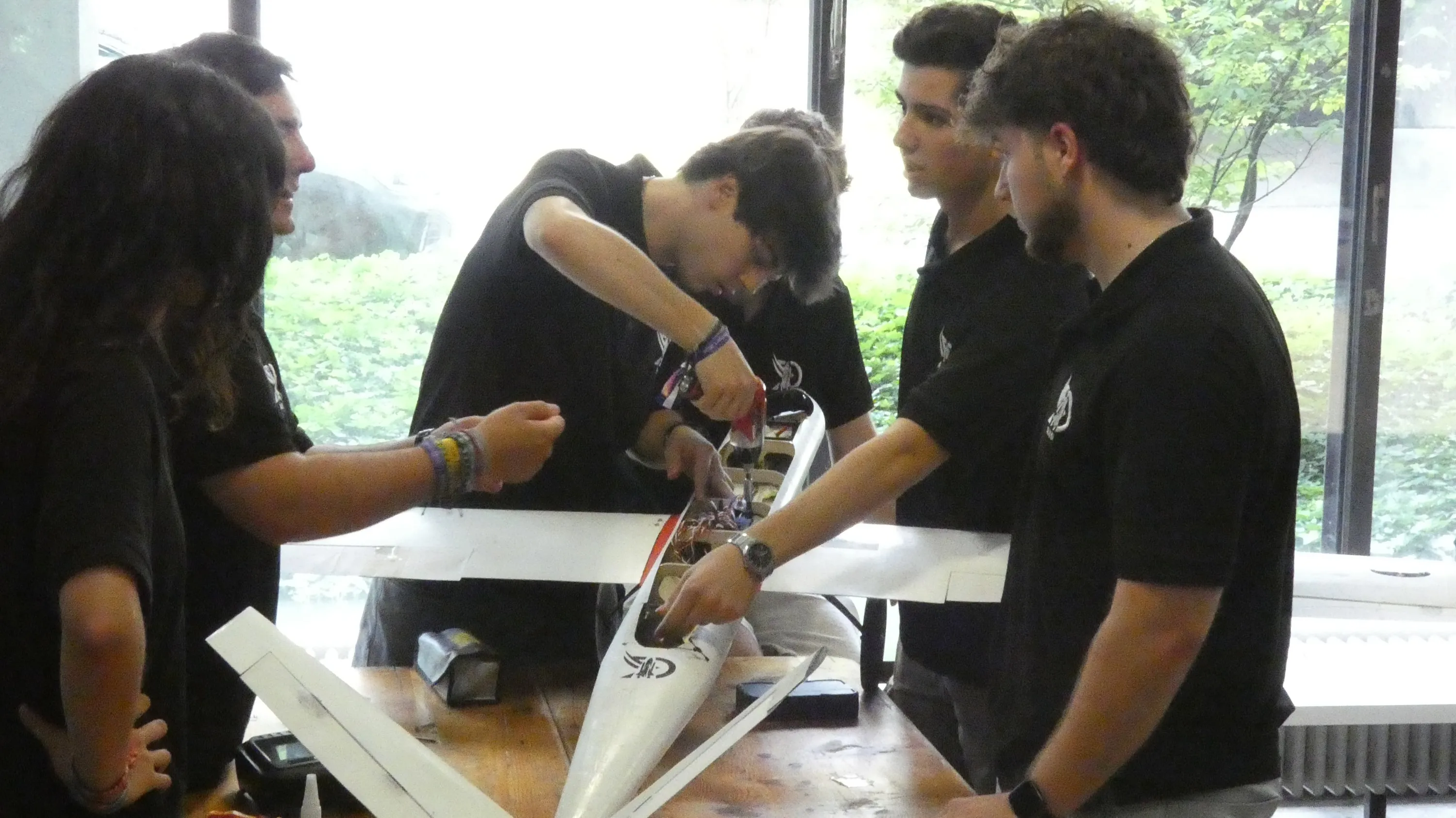 Varios miembros trabajan en el avión sobre una mesa.