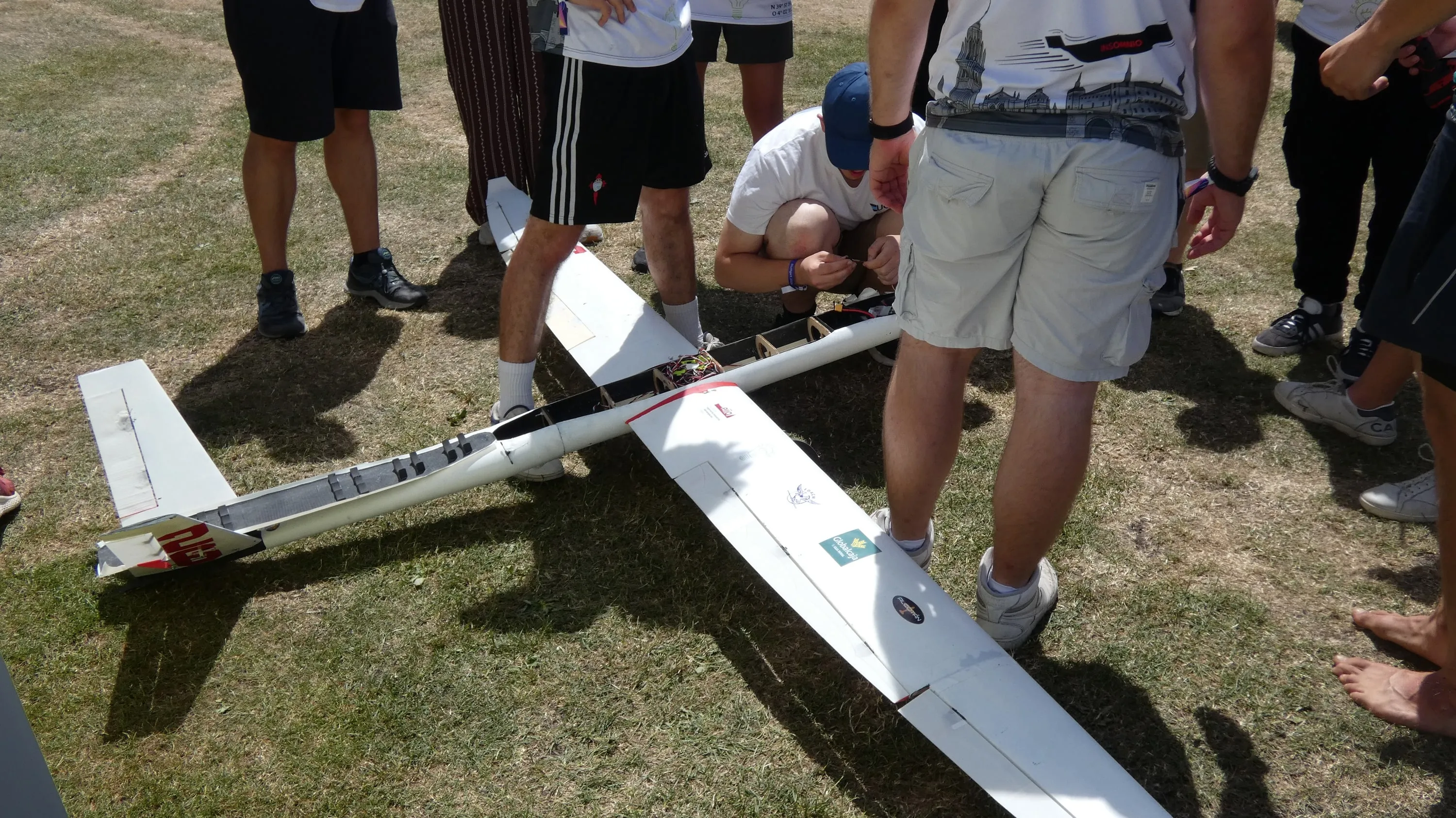 El avión en el suelo, rodeado de piernas y manos del equipo.
